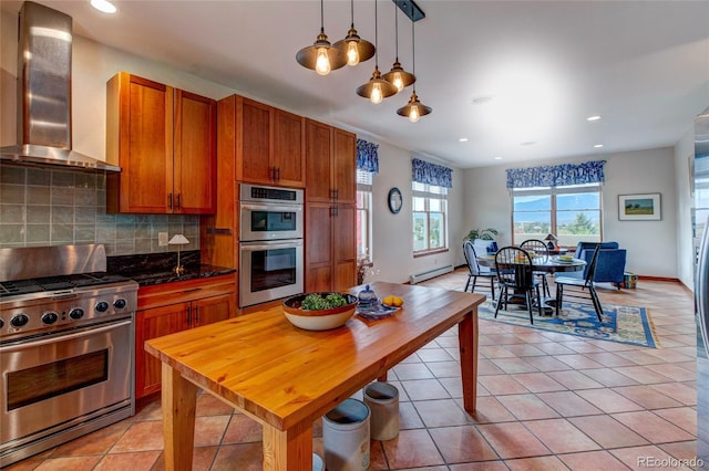 kitchen featuring decorative backsplash, wall chimney range hood, hanging light fixtures, light tile patterned floors, and appliances with stainless steel finishes