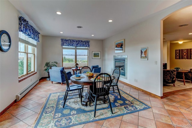 dining space with light tile patterned flooring and baseboard heating