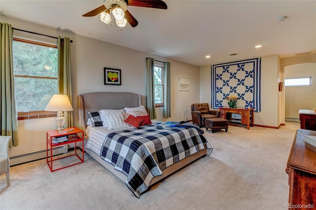 carpeted bedroom featuring baseboard heating and ceiling fan