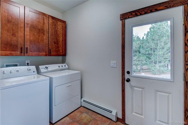 clothes washing area with a baseboard heating unit, washing machine and clothes dryer, and cabinets