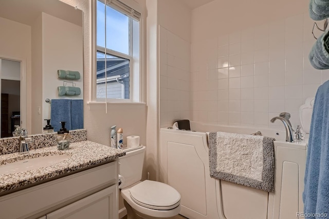 bathroom featuring a tub, vanity, and toilet