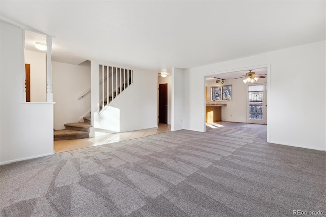 unfurnished living room featuring light colored carpet and ceiling fan