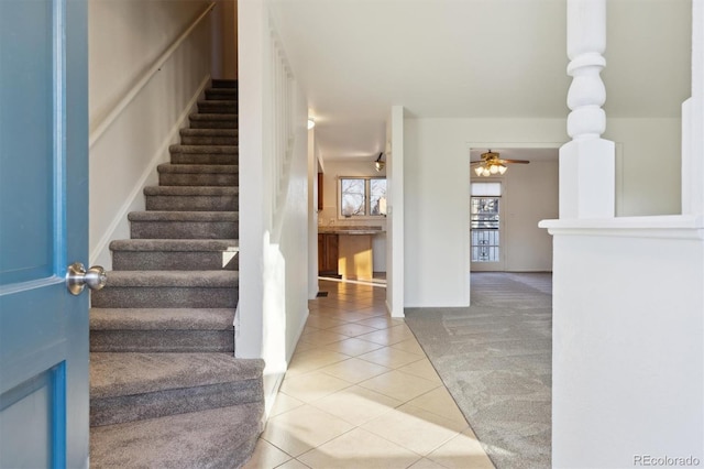 stairway with tile patterned floors and ceiling fan