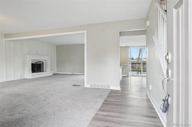 4623 S Kalispell Way, Aurora, CO 80015 - unfurnished living room with wood finished floors, a fireplace with raised hearth, and baseboards
