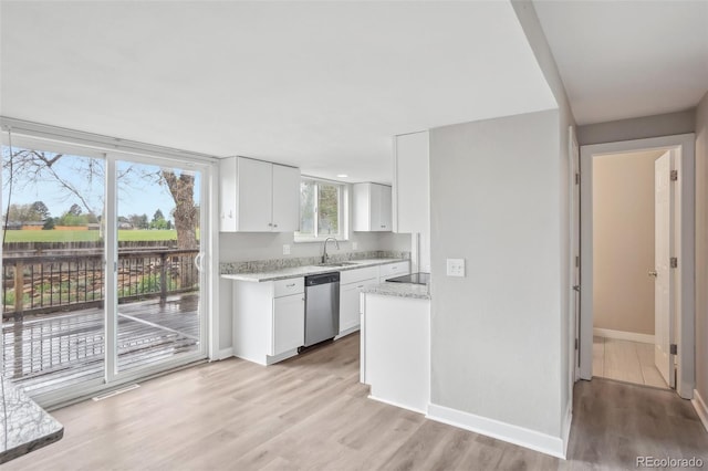 4623 S Kalispell Way, Aurora, CO 80015 - kitchen with stainless steel dishwasher, white cabinetry, a sink, light wood finished floors, and baseboards