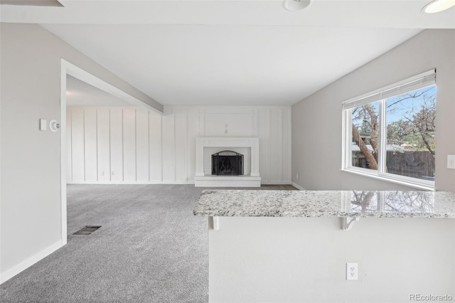 4623 S Kalispell Way, Aurora, CO 80015 - unfurnished living room featuring carpet flooring, a fireplace with raised hearth, and baseboards
