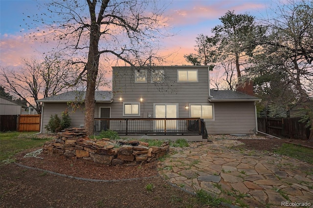4623 S Kalispell Way, Aurora, CO 80015 - back of property with a deck, a patio area, a fenced backyard, and a chimney