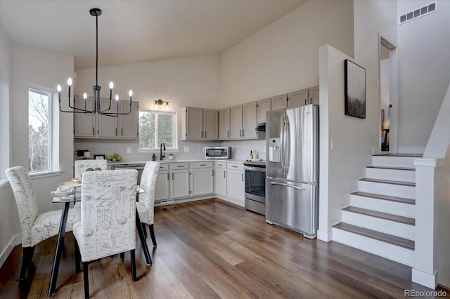 kitchen featuring stainless steel appliances, dark wood-type flooring, visible vents, a chandelier, and light countertops