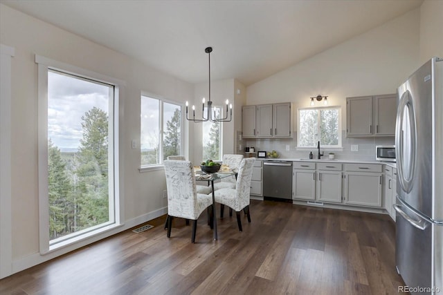 kitchen with a sink, stainless steel appliances, a notable chandelier, dark wood finished floors, and visible vents