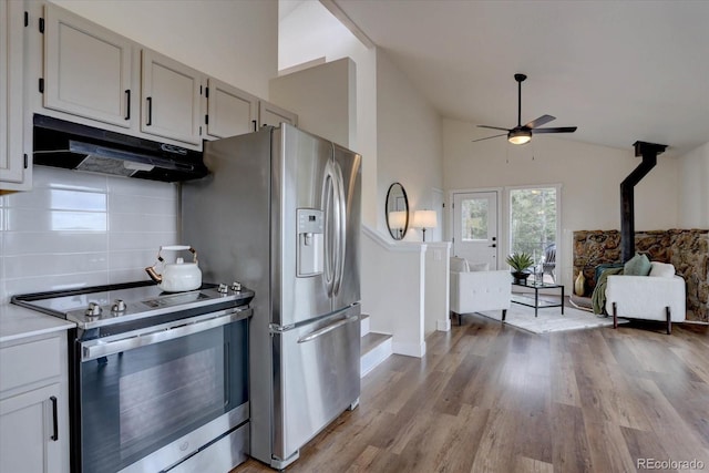 kitchen with a ceiling fan, under cabinet range hood, light wood-style floors, stainless steel appliances, and tasteful backsplash