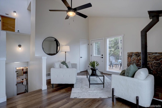 living room with visible vents, high vaulted ceiling, a ceiling fan, and wood finished floors