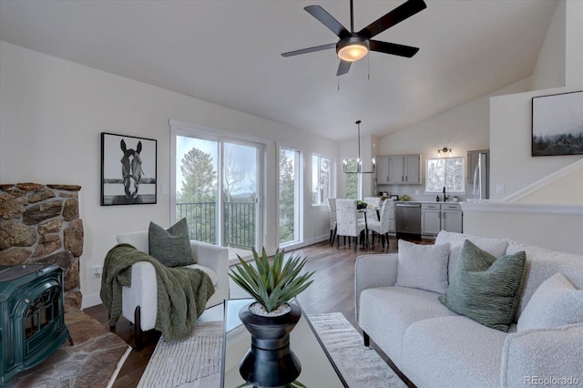 living room with a wood stove, dark wood finished floors, lofted ceiling, and ceiling fan