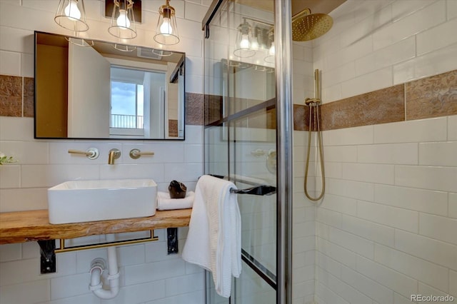 full bathroom featuring tile walls, a stall shower, and a sink