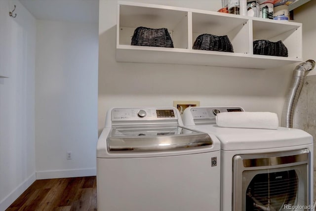 washroom featuring baseboards, laundry area, washer and dryer, and dark wood-type flooring