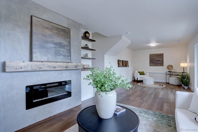 living room with wood finished floors, baseboards, and a glass covered fireplace