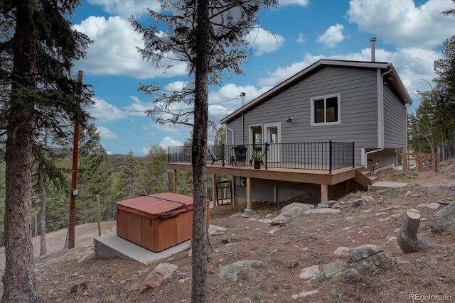 back of house featuring a deck and a hot tub