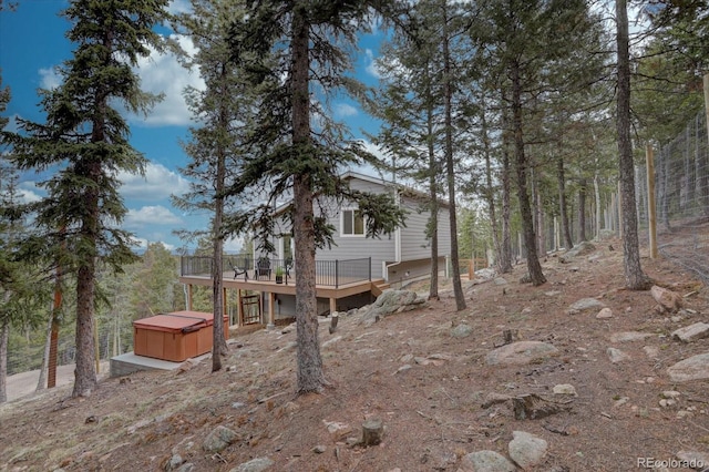 view of yard featuring a wooden deck and a hot tub