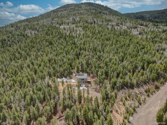 birds eye view of property featuring a wooded view and a mountain view