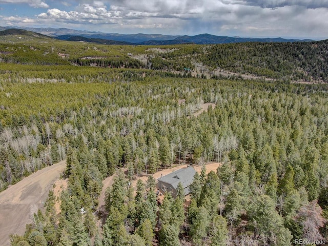 drone / aerial view featuring a forest view and a mountain view