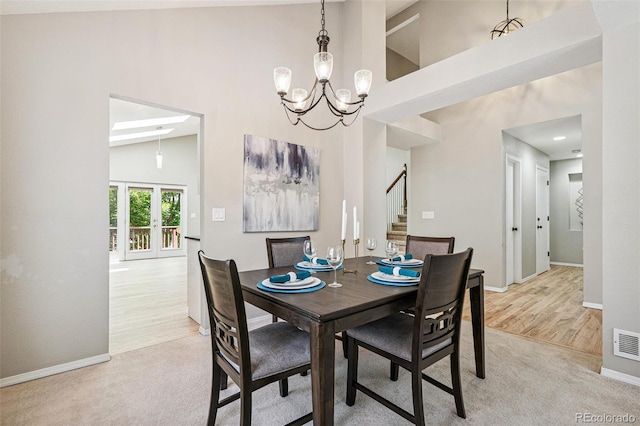 6713 W 98th Cir, Westminster, CO 80021 - dining room with high vaulted ceiling, stairway, a chandelier, light carpet, and light wood-style floors