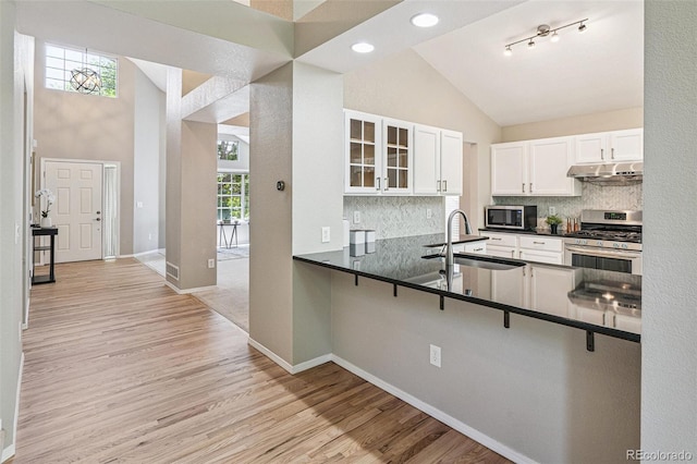 6713 W 98th Cir, Westminster, CO 80021 - kitchen featuring appliances with stainless steel finishes, dark countertops, backsplash, glass insert cabinets, and a kitchen breakfast bar