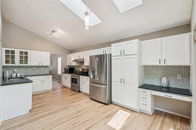 6713 W 98th Cir, Westminster, CO 80021 - kitchen featuring stainless steel appliances, a skylight, backsplash, under cabinet range hood, and light wood-type flooring