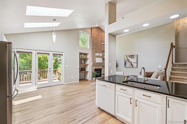 6713 W 98th Cir, Westminster, CO 80021 - kitchen featuring freestanding refrigerator, open floor plan, dishwasher, high vaulted ceiling, and a skylight