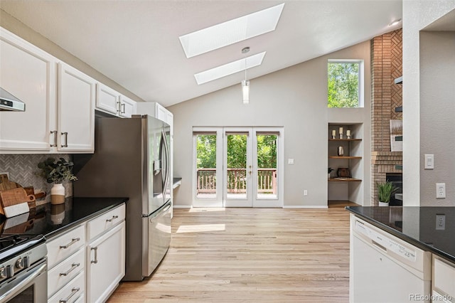6713 W 98th Cir, Westminster, CO 80021 - kitchen with appliances with stainless steel finishes, a skylight, white cabinets, light wood finished floors, and decorative light fixtures