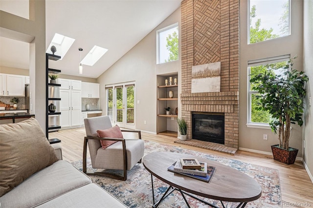 6713 W 98th Cir, Westminster, CO 80021 - living area featuring high vaulted ceiling, a skylight, a brick fireplace, and light wood finished floors