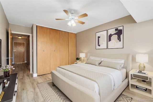 bedroom featuring light wood-type flooring, a ceiling fan, and a closet