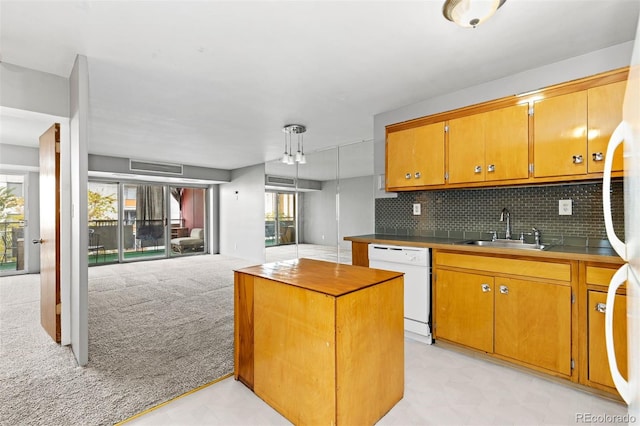 kitchen with decorative backsplash, brown cabinets, dishwasher, and a sink