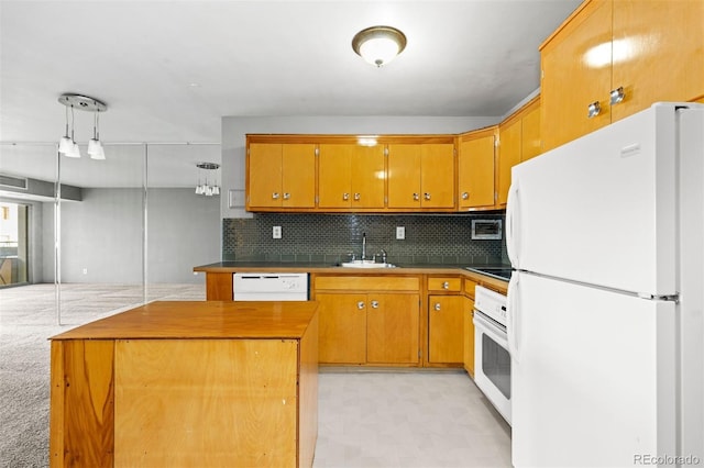 kitchen featuring white appliances, brown cabinets, a sink, and backsplash