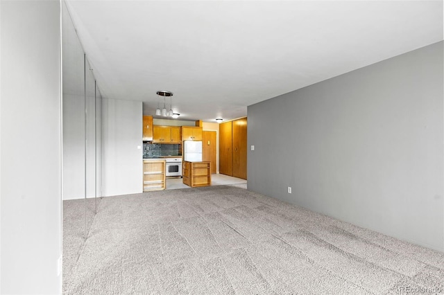 unfurnished living room with light colored carpet