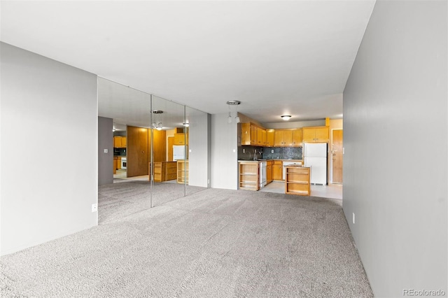 unfurnished living room featuring light colored carpet