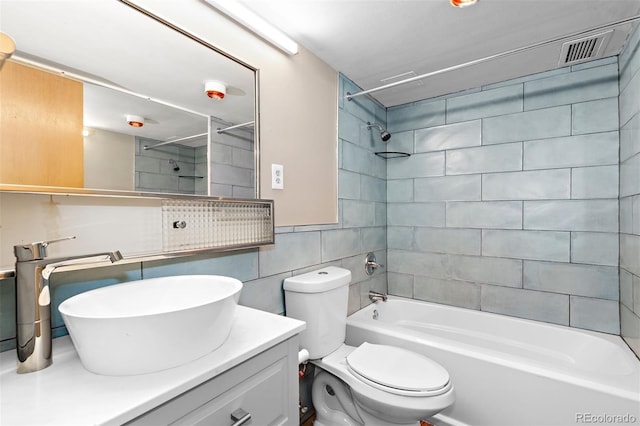 bathroom featuring tile walls, visible vents, toilet, vanity, and  shower combination