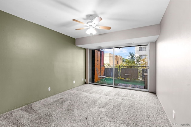 carpeted spare room featuring a ceiling fan