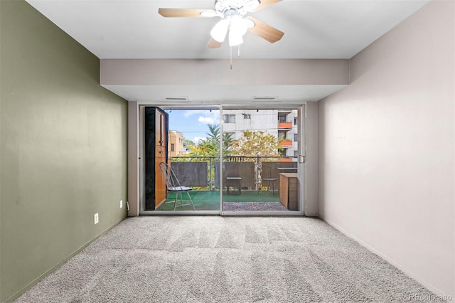 carpeted spare room with a wall of windows, a ceiling fan, and baseboards