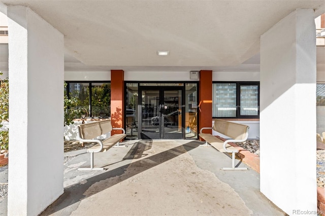 property entrance featuring a patio area and french doors