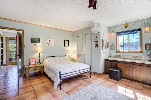 232 N 14th St, Colorado Springs, CO 80904 - bedroom with multiple windows, a sink, a closet, light tile patterned floors, and a textured ceiling