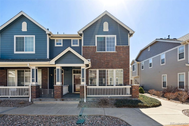 view of front of house featuring brick siding and a porch