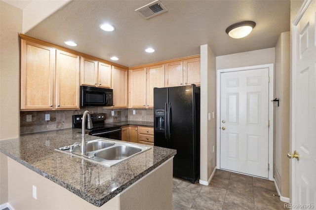 kitchen with black appliances, a peninsula, visible vents, and light brown cabinetry