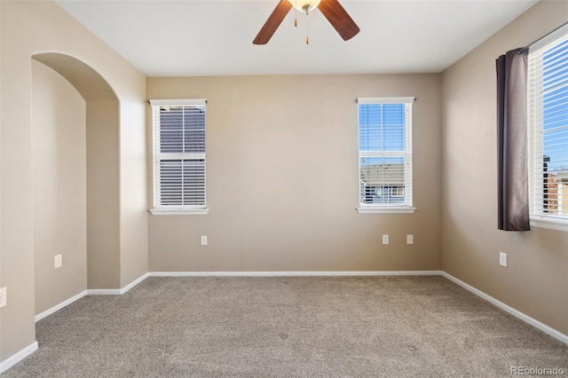 unfurnished room with baseboards, carpet, and a ceiling fan