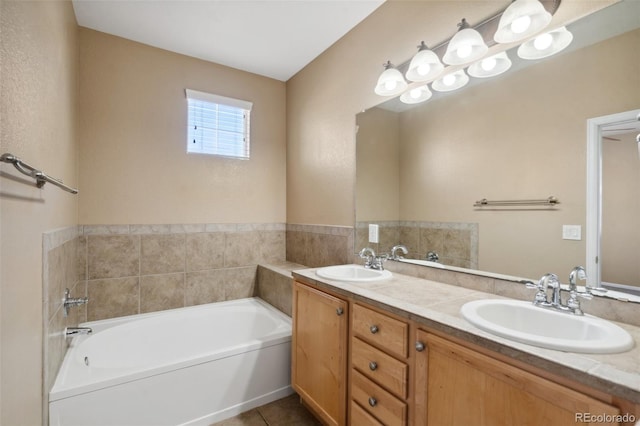 full bath featuring a bath, tile patterned floors, double vanity, and a sink