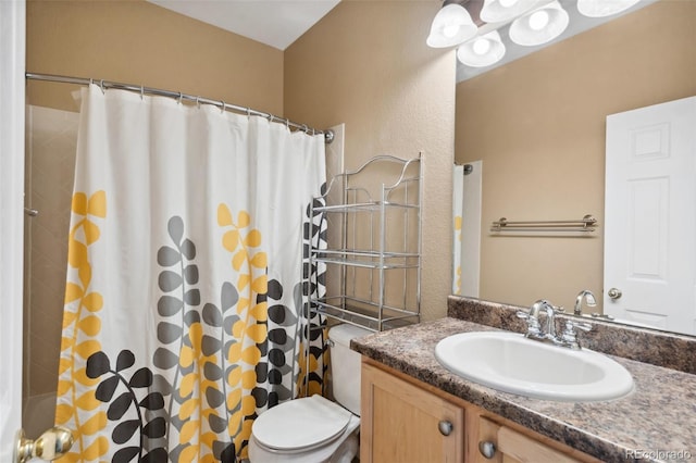 bathroom featuring toilet, vanity, and a textured wall