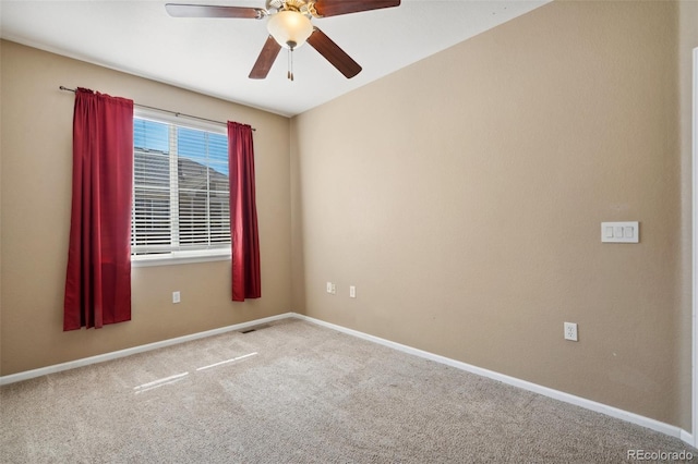 carpeted empty room featuring baseboards and a ceiling fan