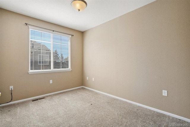 carpeted empty room with visible vents and baseboards