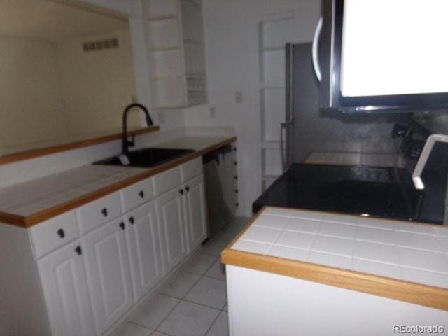 6705 S Field St Unit 802, Littleton, CO 80128 - kitchen with a sink, dishwashing machine, white cabinets, stove, and light tile patterned flooring