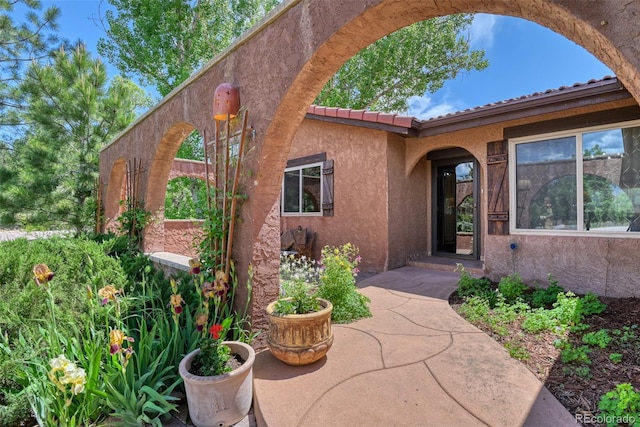 view of exterior entry with a patio