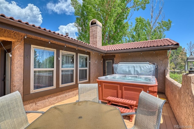 view of patio with a deck and a hot tub