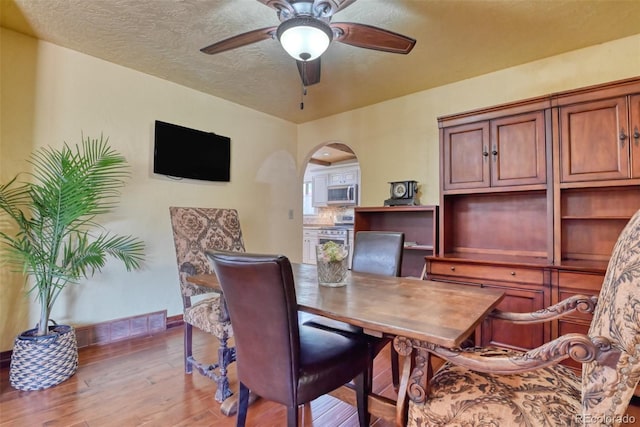 dining space featuring ceiling fan, light hardwood / wood-style floors, and a textured ceiling